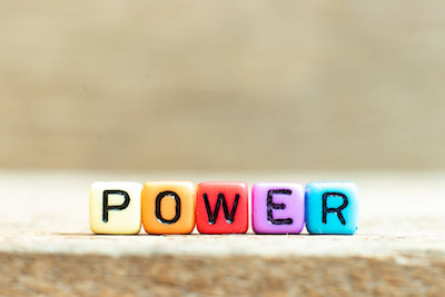 Colorful blocks spelling the word power on wood background