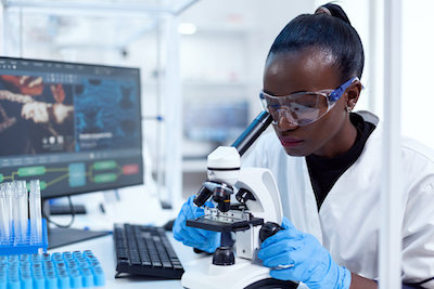 Medical researcher using microscope