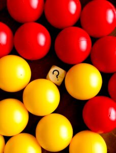 A wooden block with a painted question mark amidst a ball pit